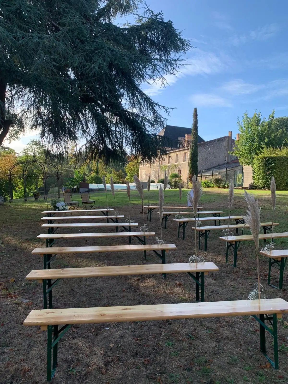 Bancs en bois installés dans le parc pour une cérémonie laïque, château en arrière-plan