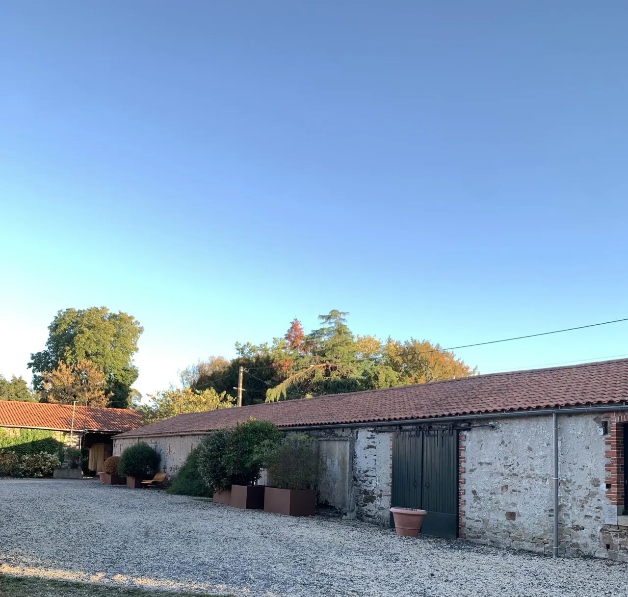 Dépendances en pierre au bord de la cour gravillonnée